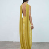 Woman wearing yellow halter maxi dress with deep V-neckline and circular buckle detail — Endless | Endless UAE