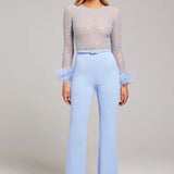 Woman wearing lavender beaded crop top with feathered cuffs and light blue wide-leg trousers — Nadine Merabi | Endless UAE