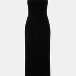 Woman wearing black halter neck velvet evening dress standing in front of historic building — COPURS | Endless UAE