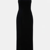 Woman wearing black halter neck velvet evening dress standing in front of historic building — COPURS | Endless UAE