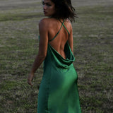 Emerald green satin maxi dress with cowl back and crossed straps in outdoor setting — Rat & Boa | Endless UAE