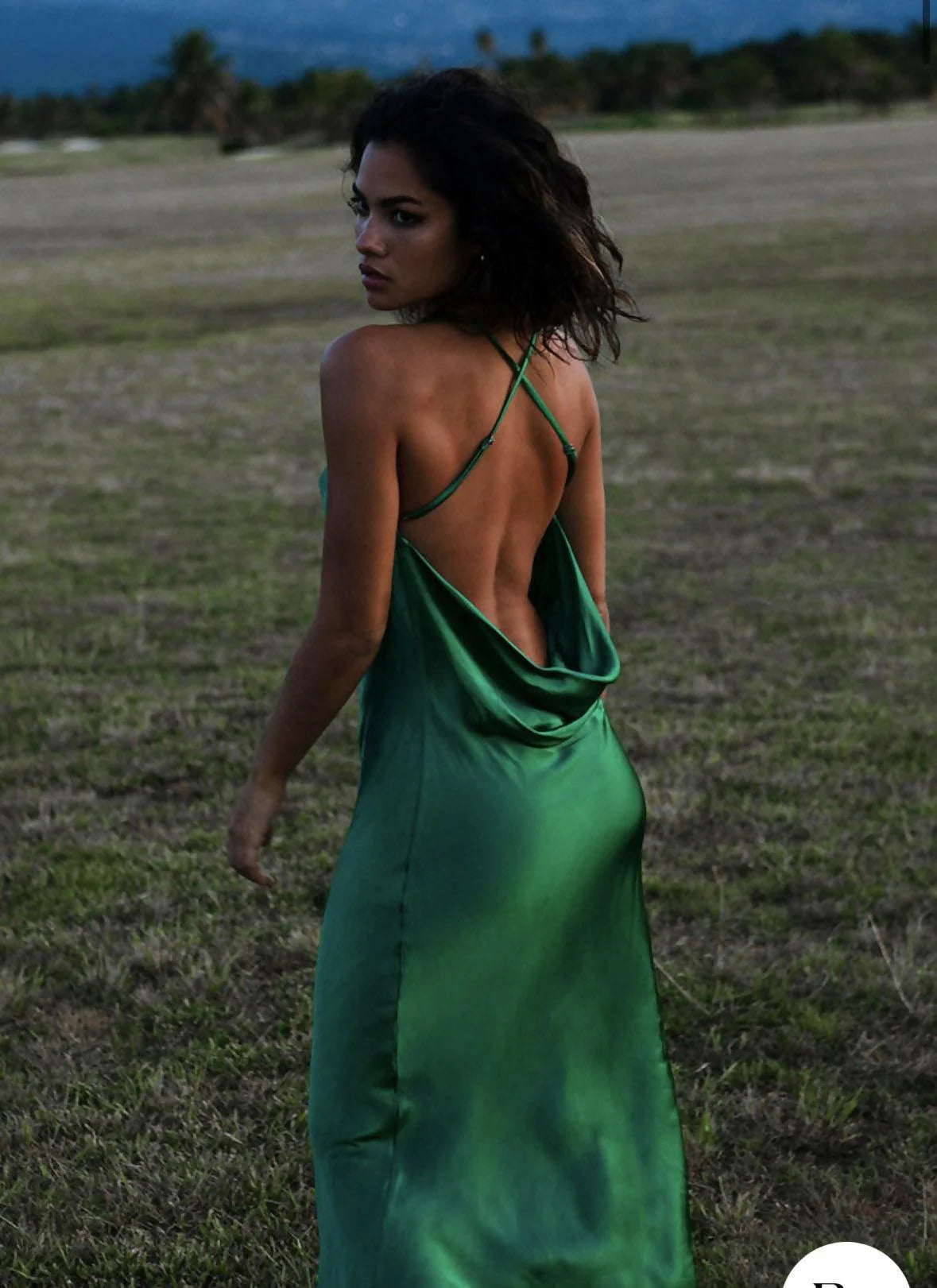 Emerald green satin maxi dress with cowl back and crossed straps in outdoor setting — Rat & Boa | Endless UAE