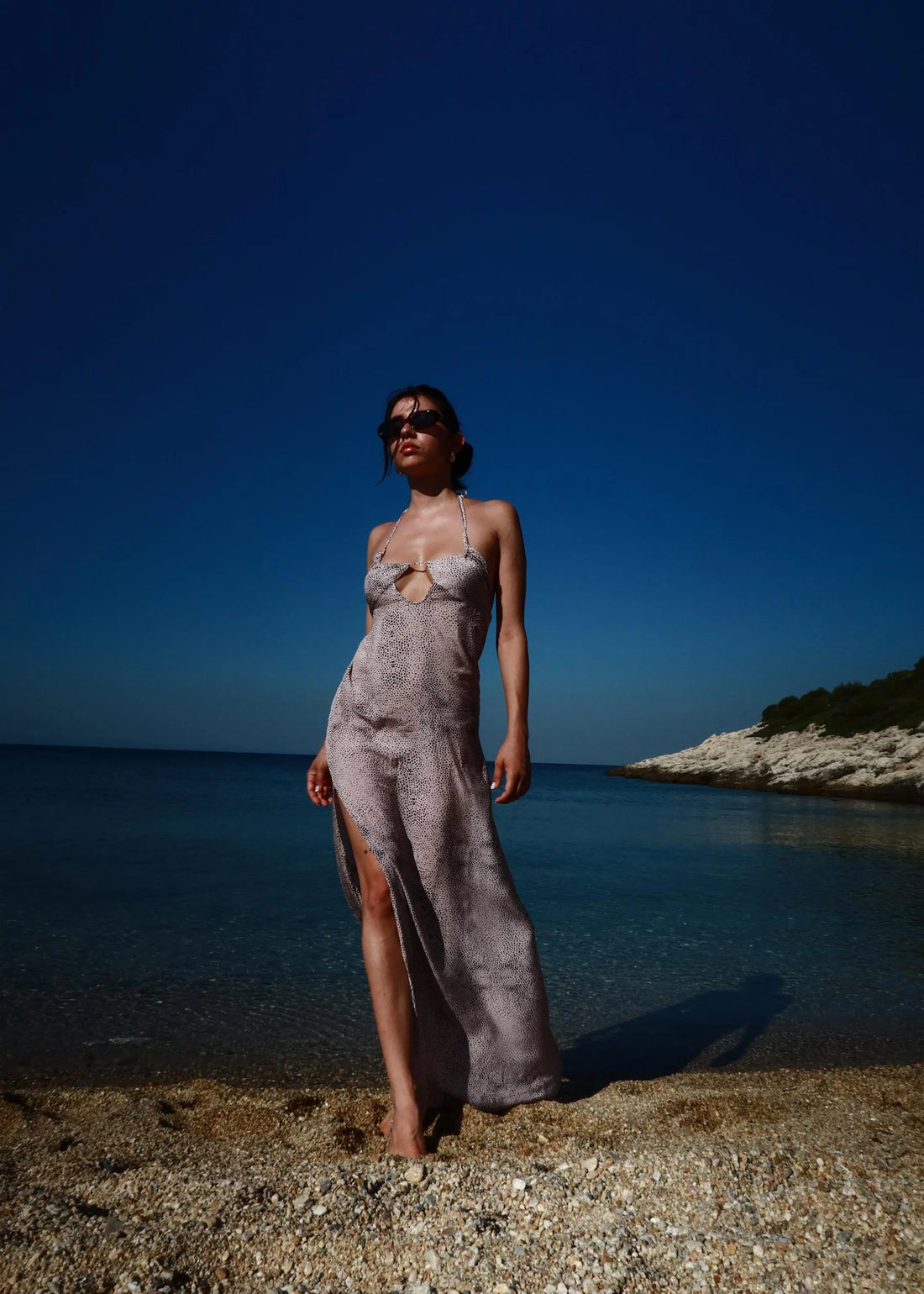 Woman wearing grey Gisele Dress standing on beach with clear blue sea — Dvete | Endless UAE
