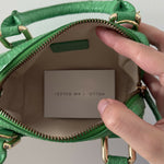 Green crocodile-embossed mini tote bag with gold hardware held by hand — By Far | Endless UAE