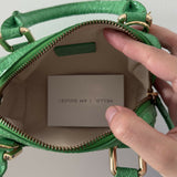 Green crocodile-embossed mini tote bag with gold hardware held by hand — By Far | Endless UAE