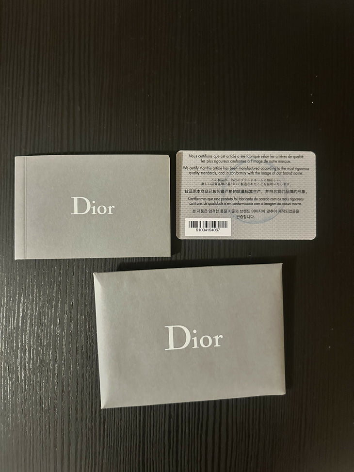 Elegant beige Dior branded boxes with authentication card on dark wooden surface — Christian Dior | Endless UAE