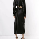 Black silk wrap shirt with open back cutout and tie detail, long sleeves, midi length skirt, worn with strappy heels — Christopher Esber | Endless UAE