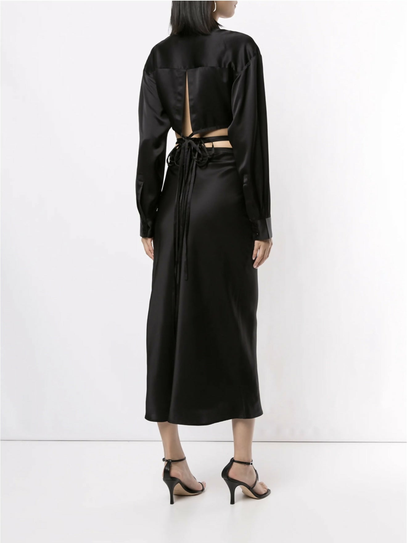 Black silk wrap shirt with open back cutout and tie detail, long sleeves, midi length skirt, worn with strappy heels — Christopher Esber | Endless UAE