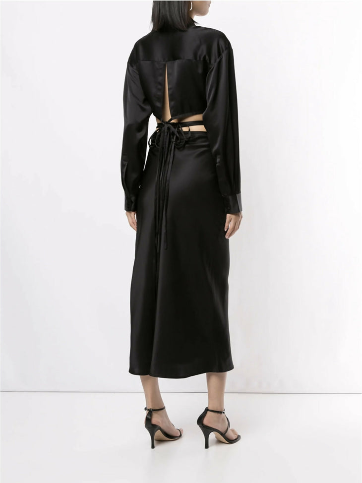 Black silk wrap shirt with open back cutout and tie detail, long sleeves, midi length skirt, worn with strappy heels — Christopher Esber | Endless UAE