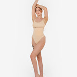 Woman wearing beige high waist thong in standing pose — Underhance | Endless UAE