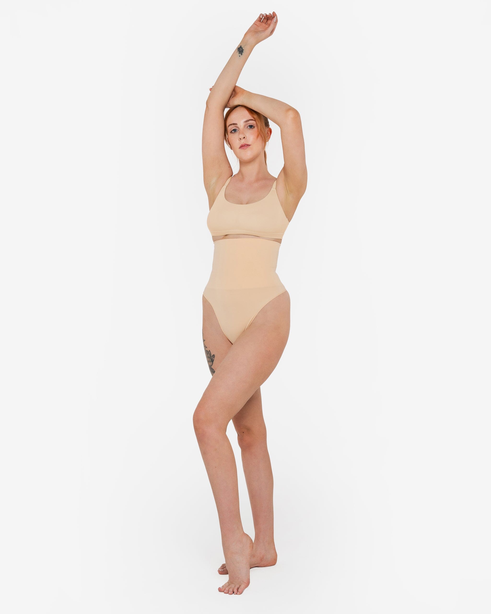 Woman wearing beige high waist thong in standing pose — Underhance | Endless UAE