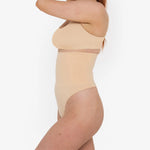 Woman wearing beige high waist thong in standing pose — Underhance | Endless UAE