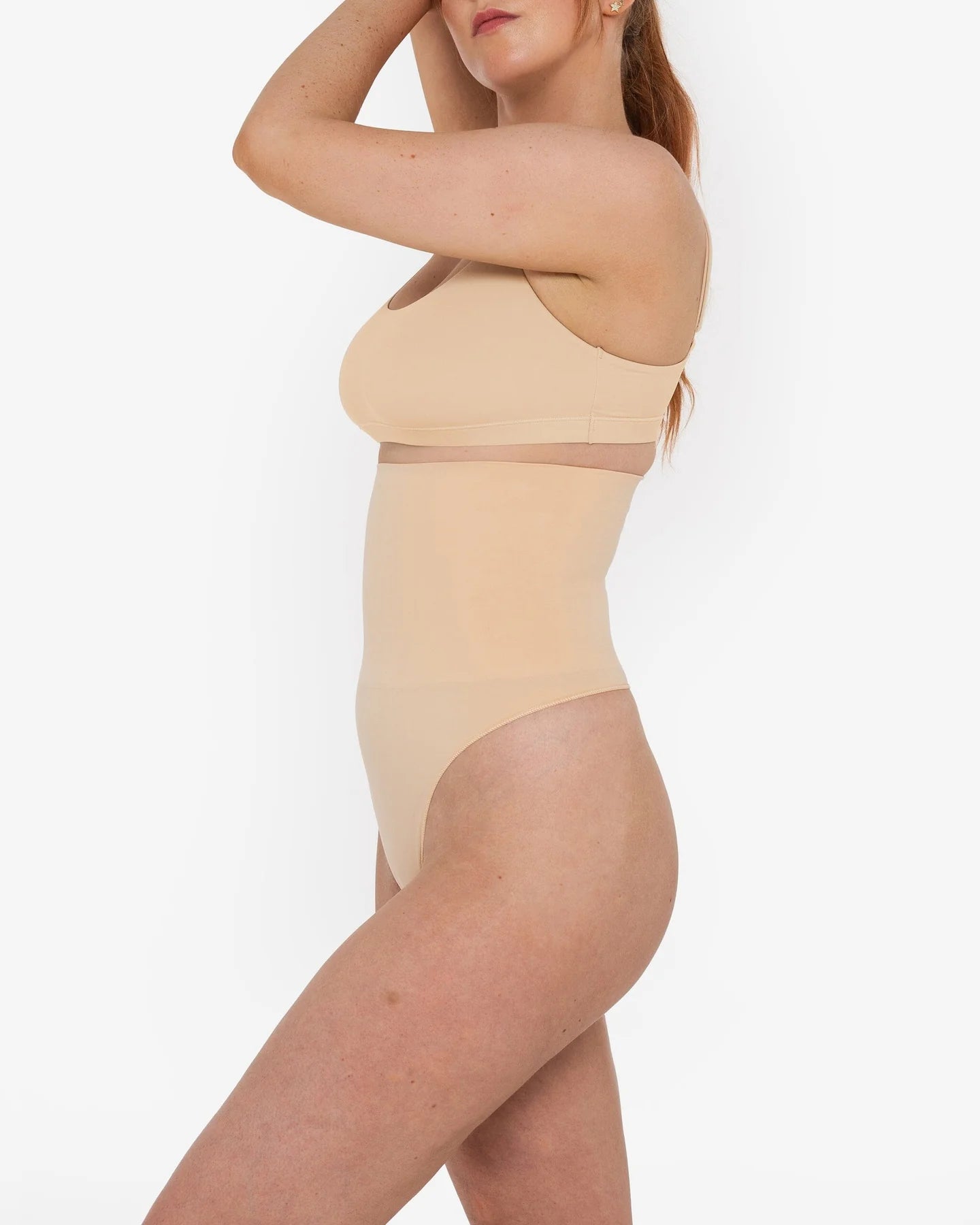Woman wearing beige high waist thong in standing pose — Underhance | Endless UAE