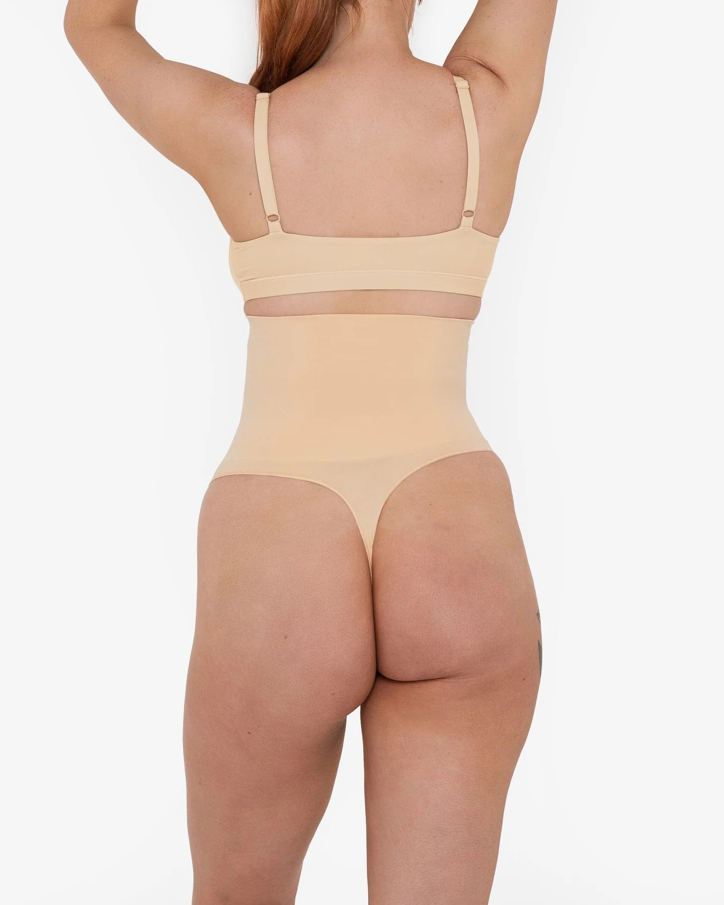 Woman wearing beige high waist thong in standing pose — Underhance | Endless UAE