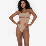 Woman wearing beige high waist thong in standing pose — Underhance | Endless UAE