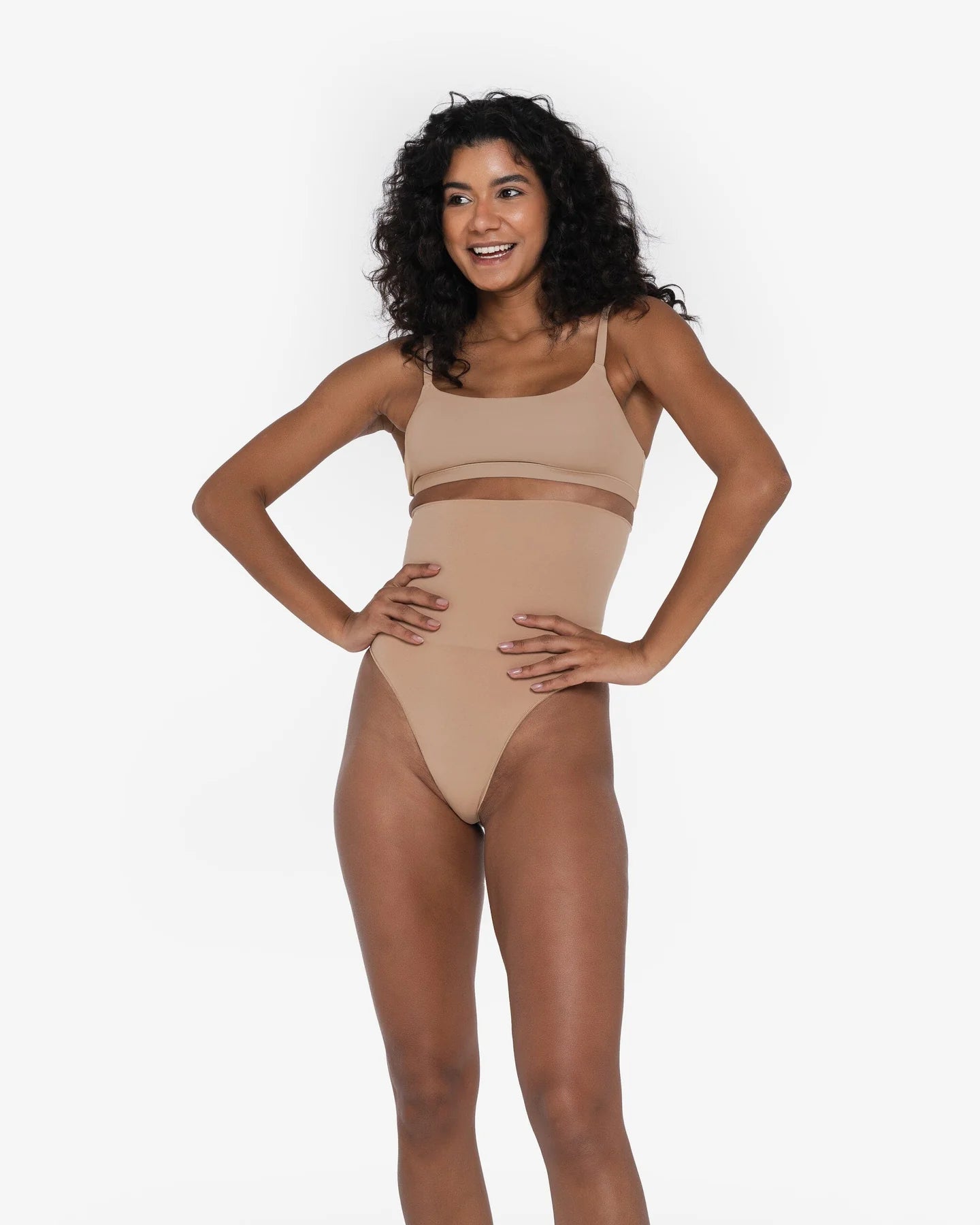 Woman wearing beige high waist thong in standing pose — Underhance | Endless UAE