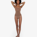 Woman wearing beige high waist thong in standing pose — Underhance | Endless UAE