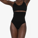 Woman wearing beige high waist thong in standing pose — Underhance | Endless UAE