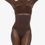 Woman wearing beige high waist thong in standing pose — Underhance | Endless UAE