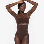 Woman wearing beige high waist thong in standing pose — Underhance | Endless UAE