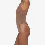 Woman wearing beige high waist thong in standing pose — Underhance | Endless UAE