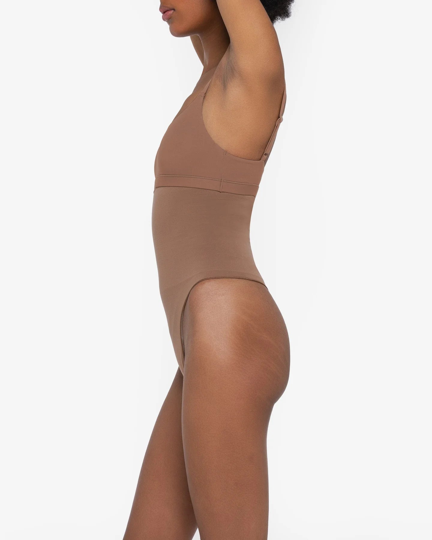 Woman wearing beige high waist thong in standing pose — Underhance | Endless UAE