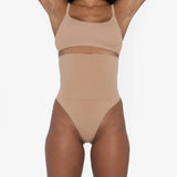 Woman wearing beige high waist thong in standing pose — Underhance | Endless UAE