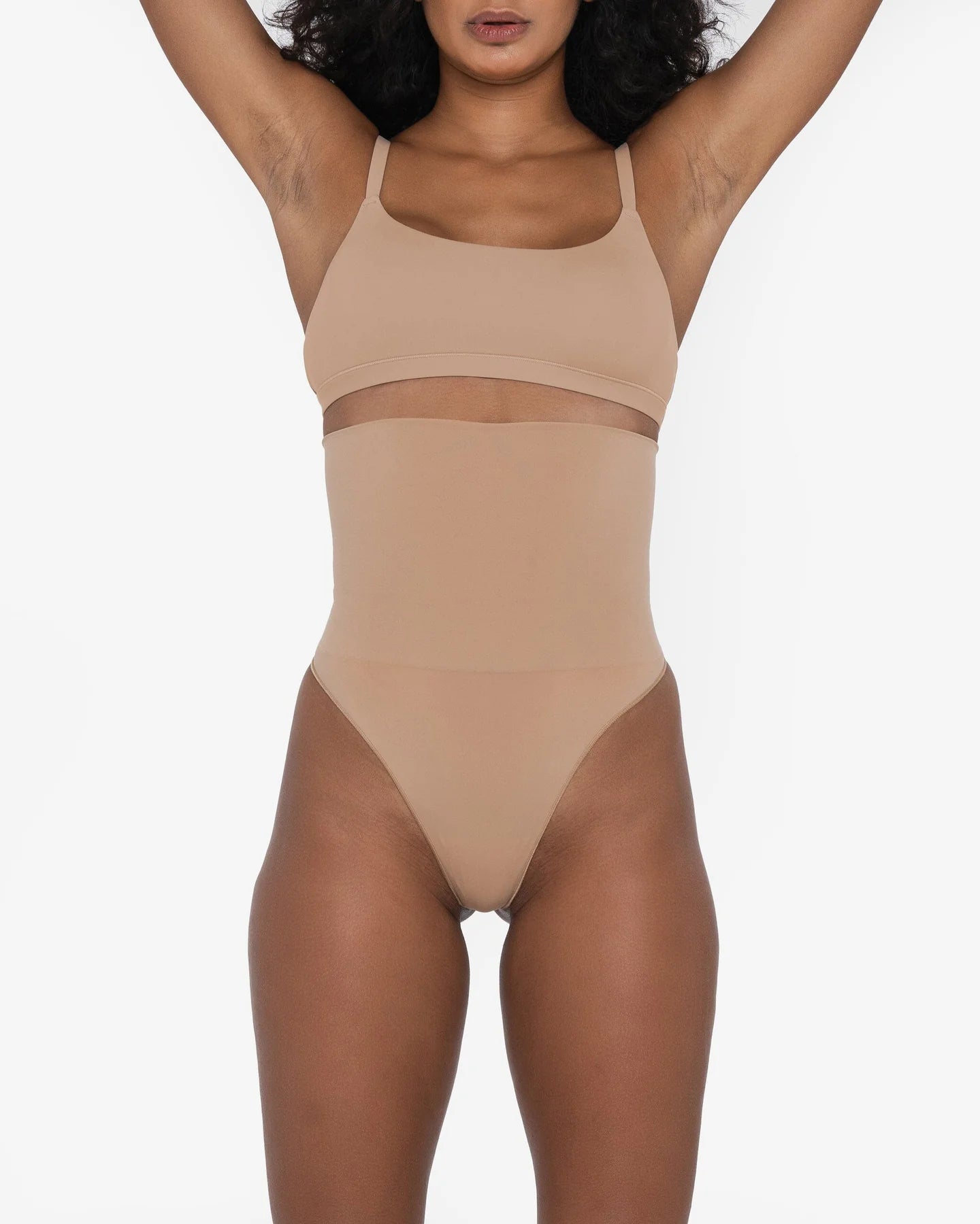 Woman wearing beige high waist thong in standing pose — Underhance | Endless UAE