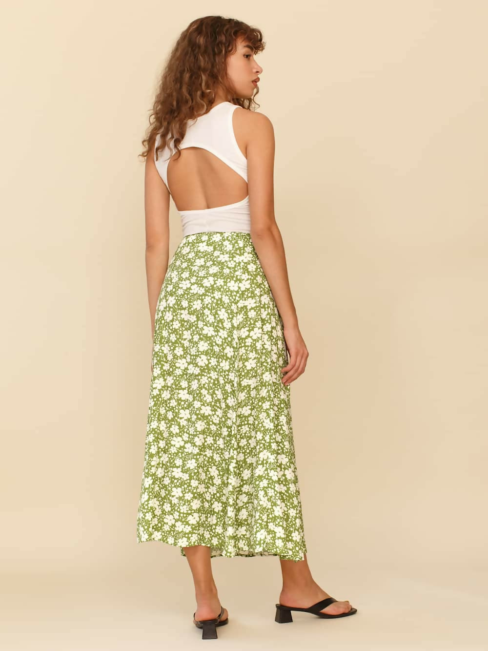 Woman wearing white sleeveless tank top and green floral midi skirt with side slit — Endless | Endless UAE