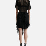 Black ruched dress with sheer tulle overlay, asymmetric hem, and short sleeves, shown from back — Ester Manas | Endless UAE