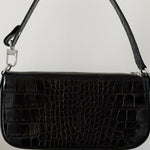 Black crocodile embossed leather shoulder bag held in hand against white background — By Far | Endless UAE