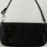 Black crocodile embossed leather shoulder bag held in hand against white background — By Far | Endless UAE