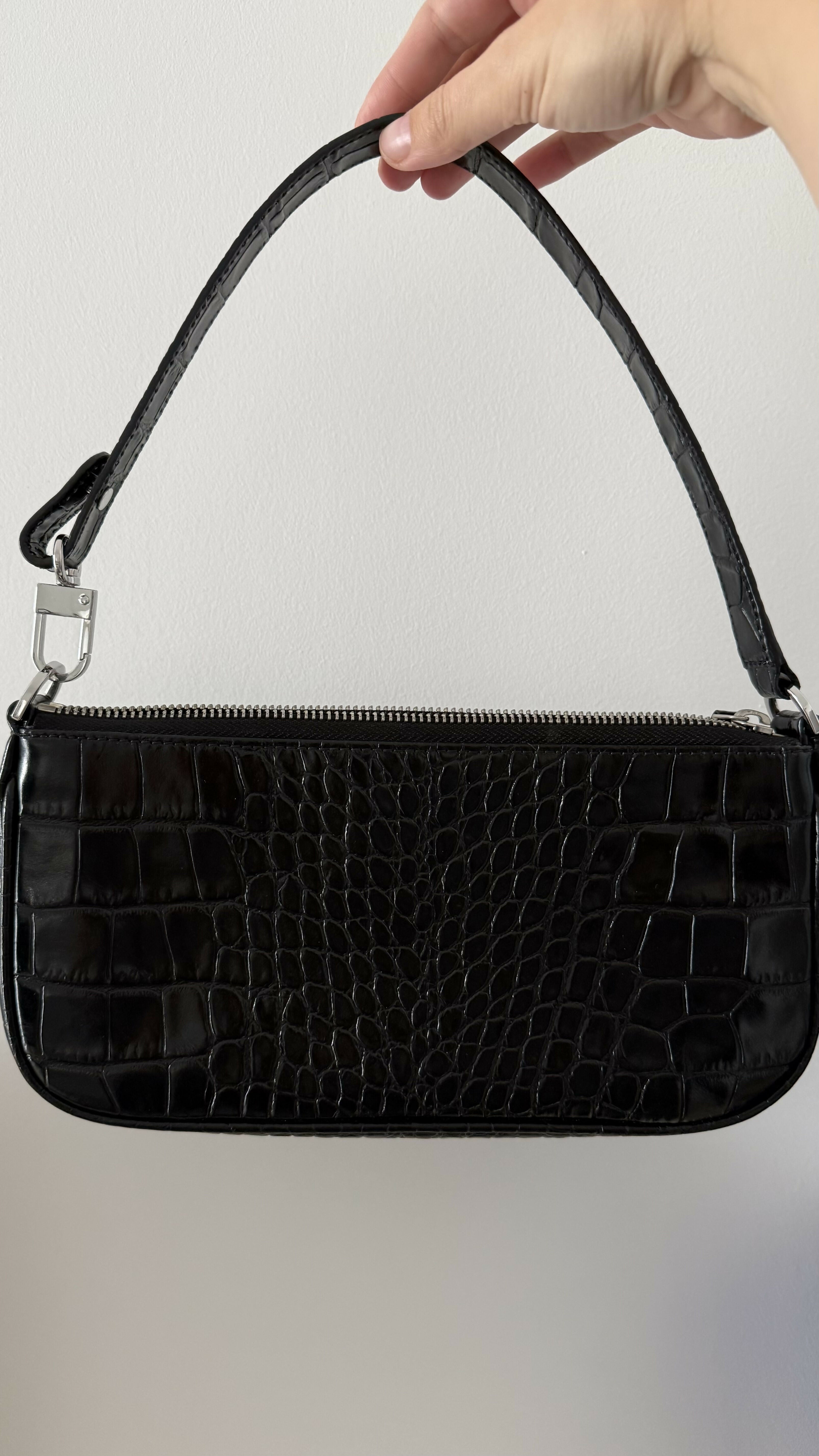 Black crocodile embossed leather shoulder bag held in hand against white background — By Far | Endless UAE