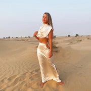 Cream Faye Co-ord Set featuring draped crop top and maxi skirt on model in desert landscape — Deme Studio | Endless UAE