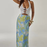 Woman wearing white halter cut-out crop top with blue and green floral maxi skirt — Runaway The Label | Endless UAE