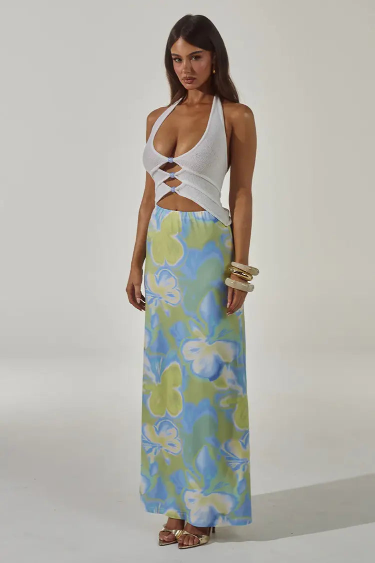 Woman wearing white halter cut-out crop top with blue and green floral maxi skirt — Runaway The Label | Endless UAE