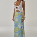 Woman wearing white halter cut-out crop top with blue and green floral maxi skirt — Runaway The Label | Endless UAE