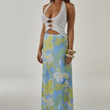Woman wearing white halter cut-out crop top with blue and green floral maxi skirt — Runaway The Label | Endless UAE