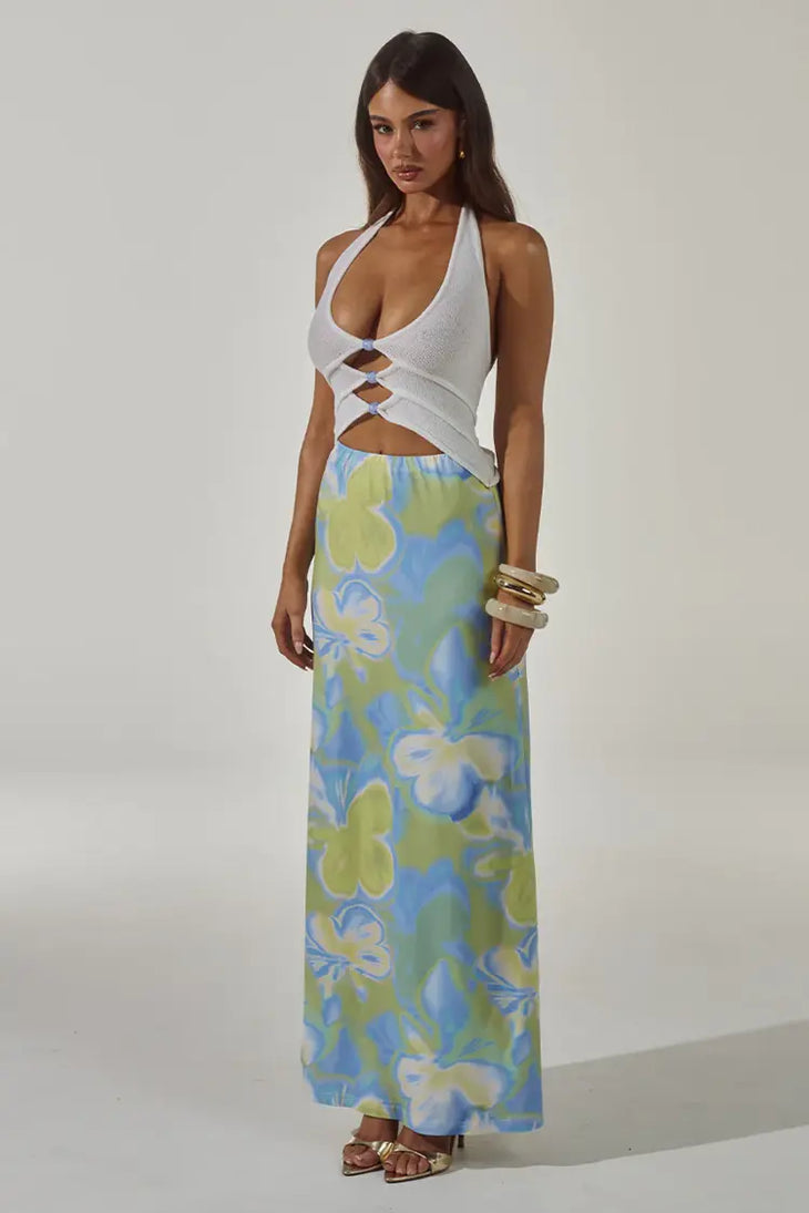 Woman wearing white halter cut-out crop top with blue and green floral maxi skirt — Runaway The Label | Endless UAE