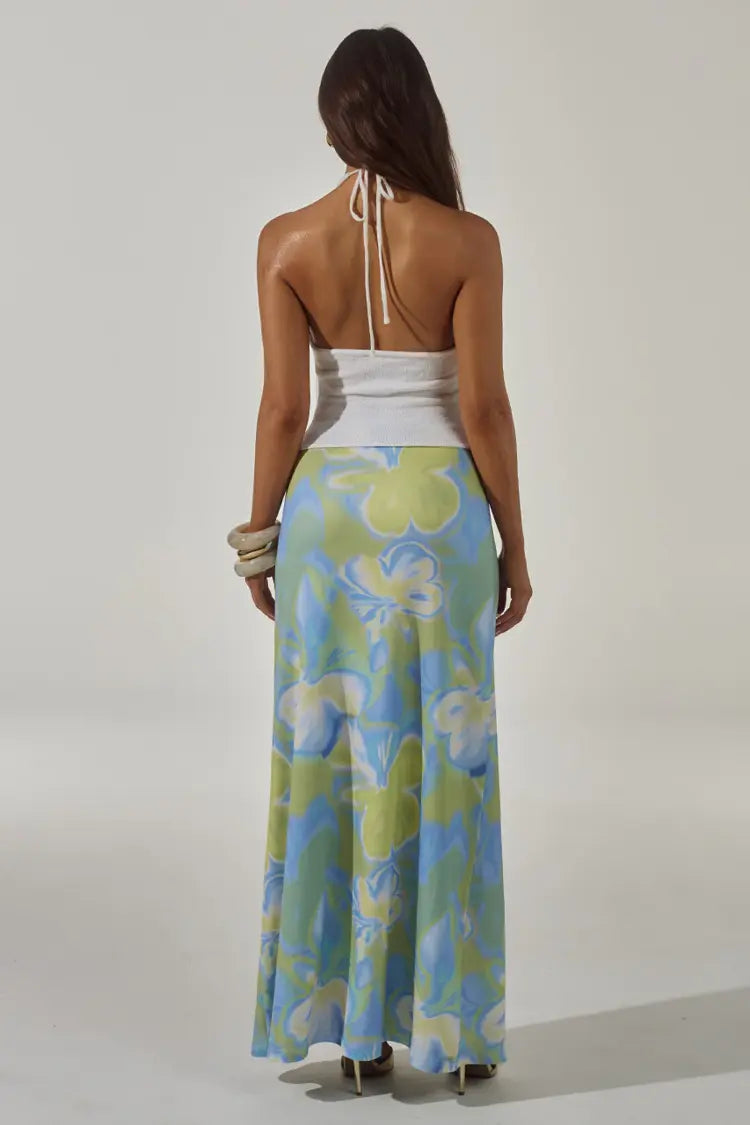 Woman wearing white halter cut-out crop top with blue and green floral maxi skirt — Runaway The Label | Endless UAE
