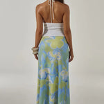 Woman wearing white halter cut-out crop top with blue and green floral maxi skirt — Runaway The Label | Endless UAE