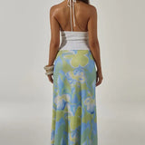 Woman wearing white halter cut-out crop top with blue and green floral maxi skirt — Runaway The Label | Endless UAE