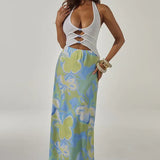 Woman wearing white halter cut-out crop top with blue and green floral maxi skirt — Runaway The Label | Endless UAE