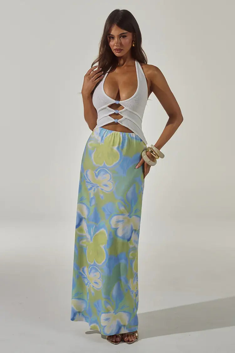 Woman wearing white halter cut-out crop top with blue and green floral maxi skirt — Runaway The Label | Endless UAE