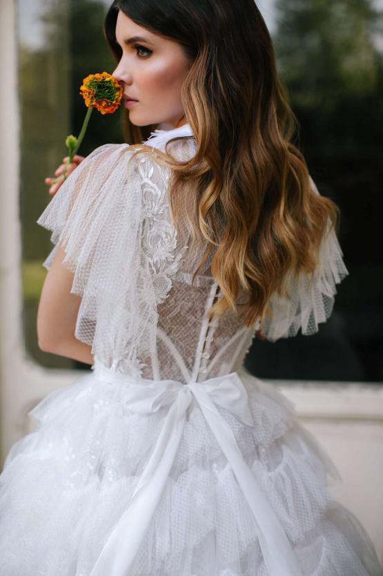 Elegant tulle bridal gown with lace detailing, ruffled sleeves and ribbon waist tie, back view — Blammo Biamo | Endless UAE