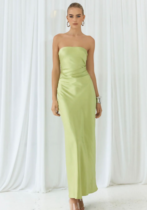 Woman wearing lime green strapless maxi dress against white curtain backdrop — Endless | Endless UAE