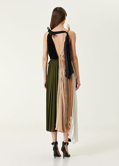 Woman wearing pleated asymmetric maxi dress in black, blush pink and red with black ankle strap heels — Victoria Beckham | Endless UAE