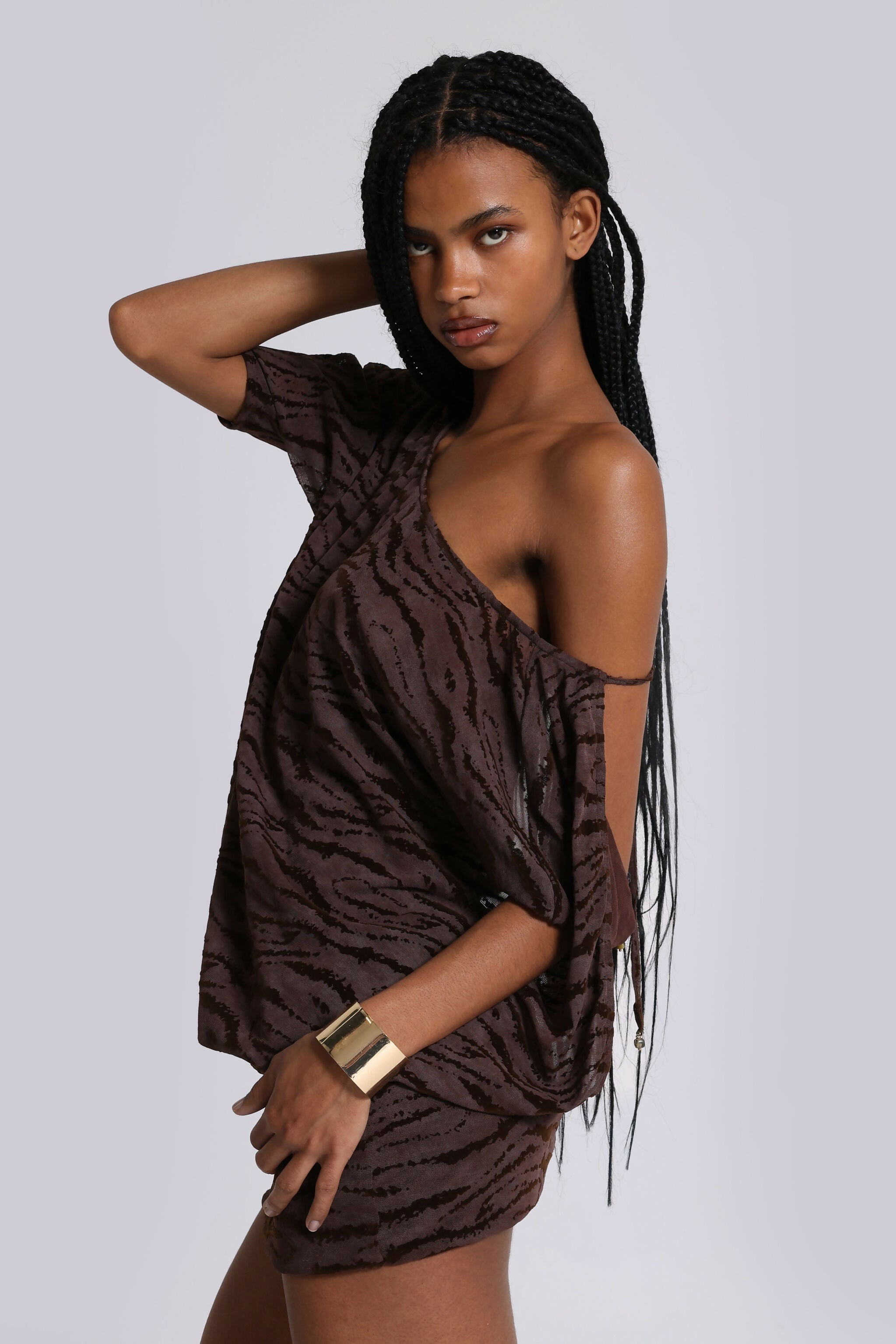 Model wearing brown zebra print backless mini dress with one shoulder sleeve and gold cuff bracelet — Jaded London | Endless UAE