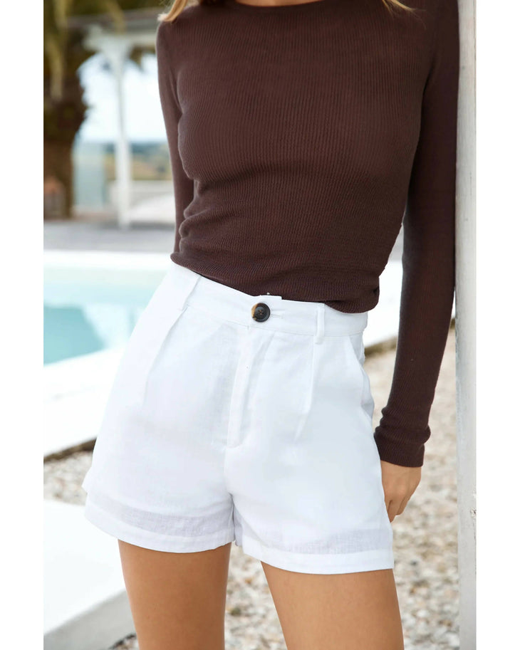 White linen high-waisted shorts with cuffed hem and button closure paired with brown ribbed top — Sandys | Endless UAE