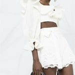 White embroidered shorts with scalloped hem and belted waist detail on model — Zimmermann | Endless UAE